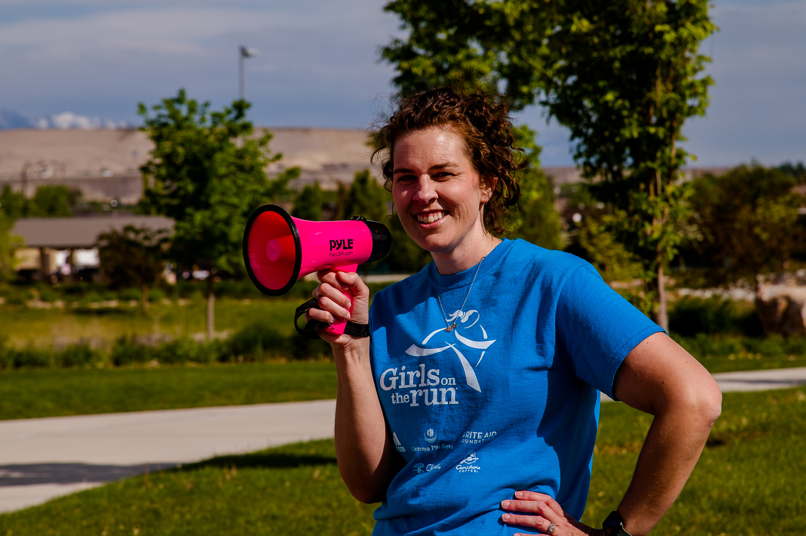 A Girls on the Run is smiling at the camera wearing a blue program shirt